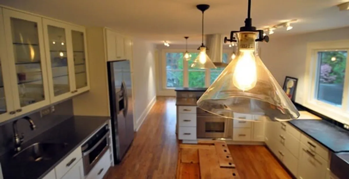 Residential electrician installing modern indoor light fixture in a home in Memphis, TN